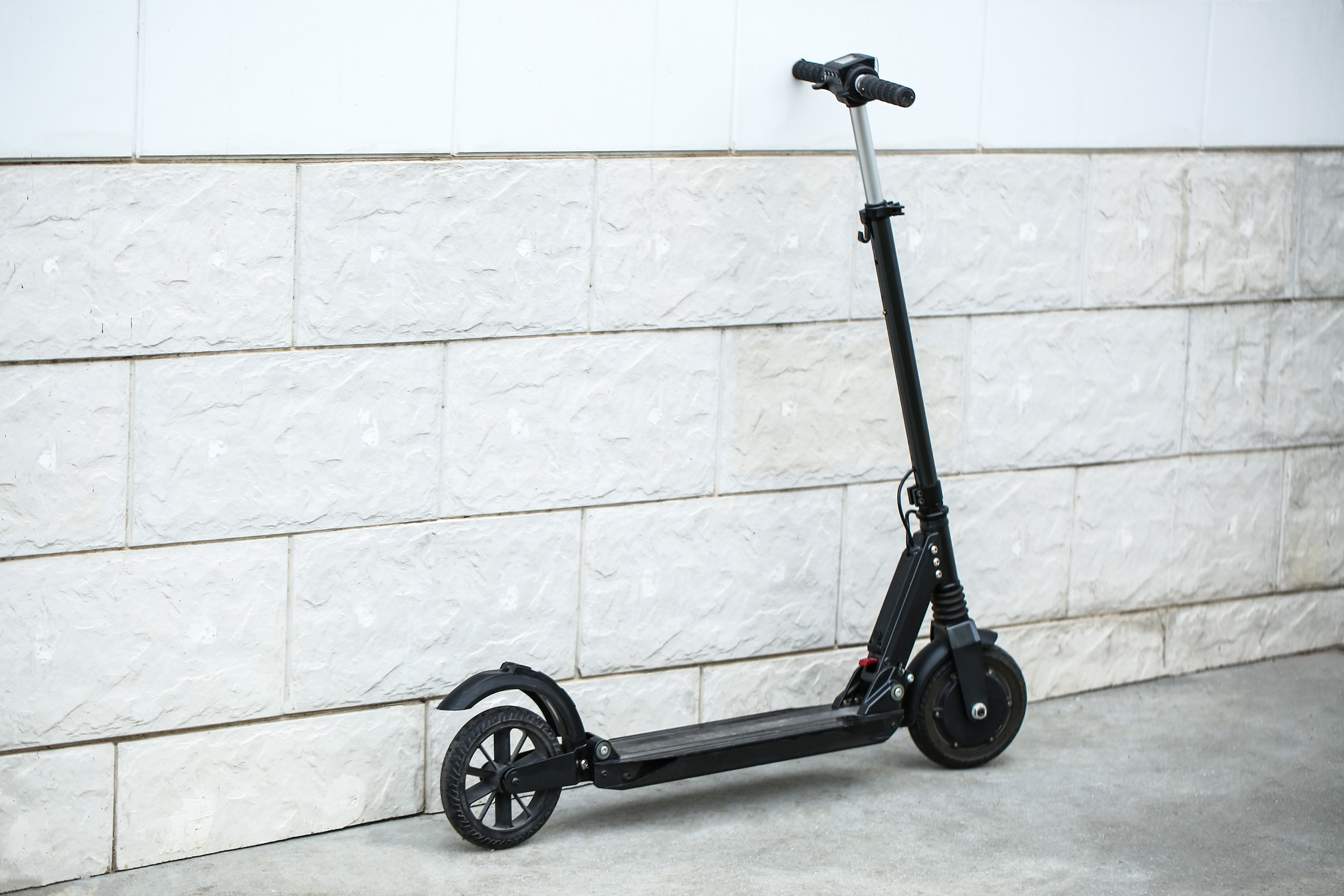 An e-scooter leaning against a wall