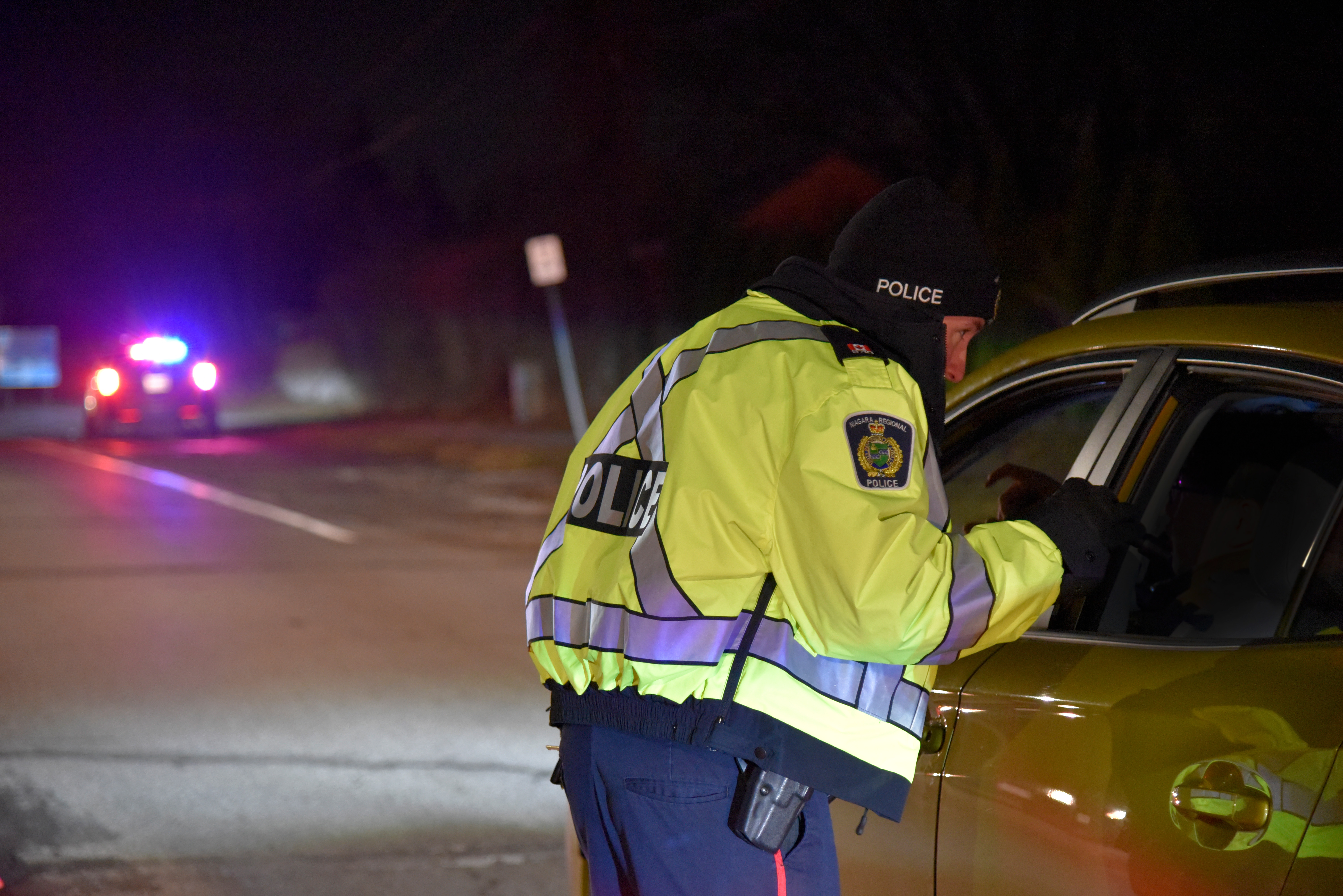 a police officer talking to someone through their car window at night