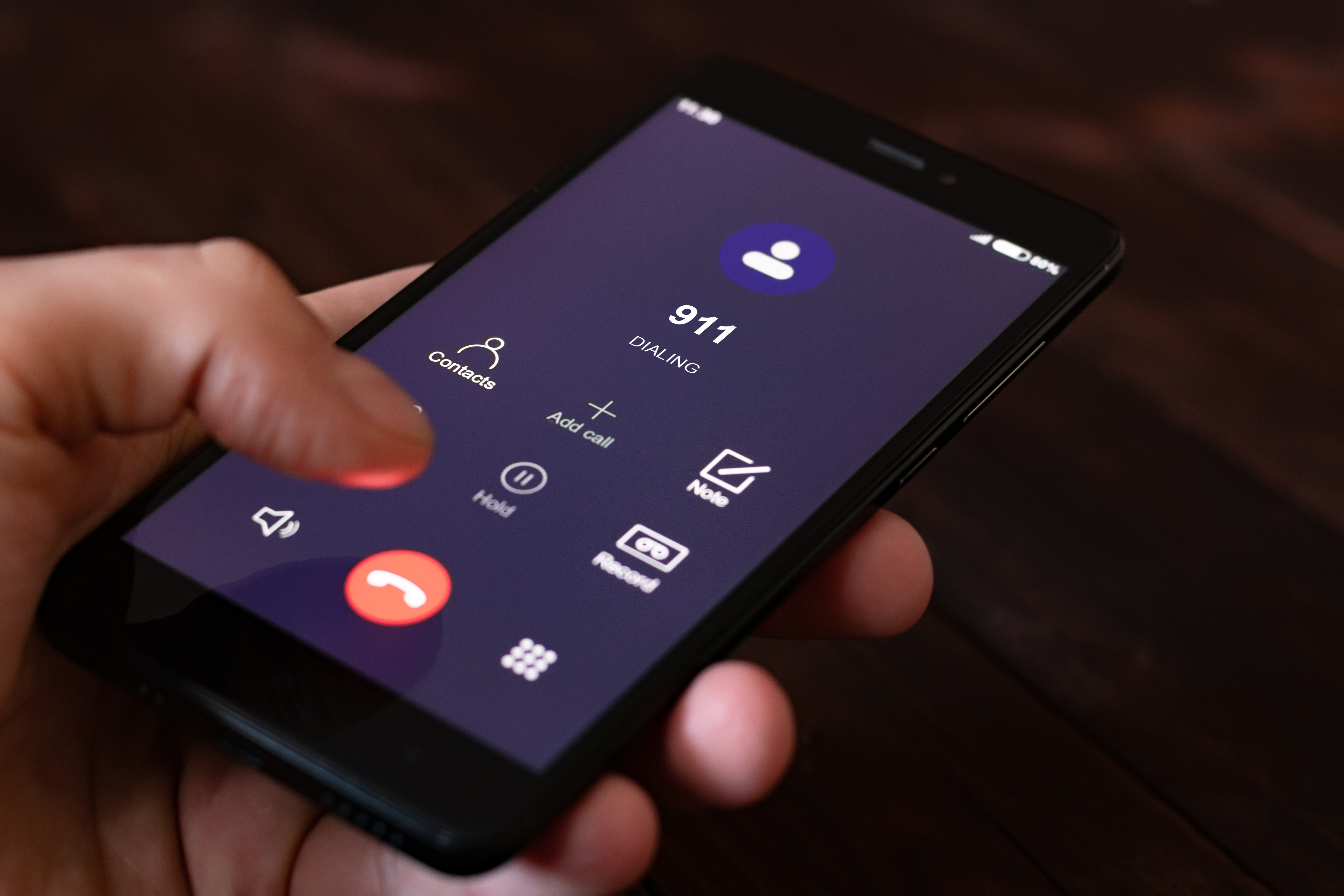 Alt =A person dialing 911 on a cell phone