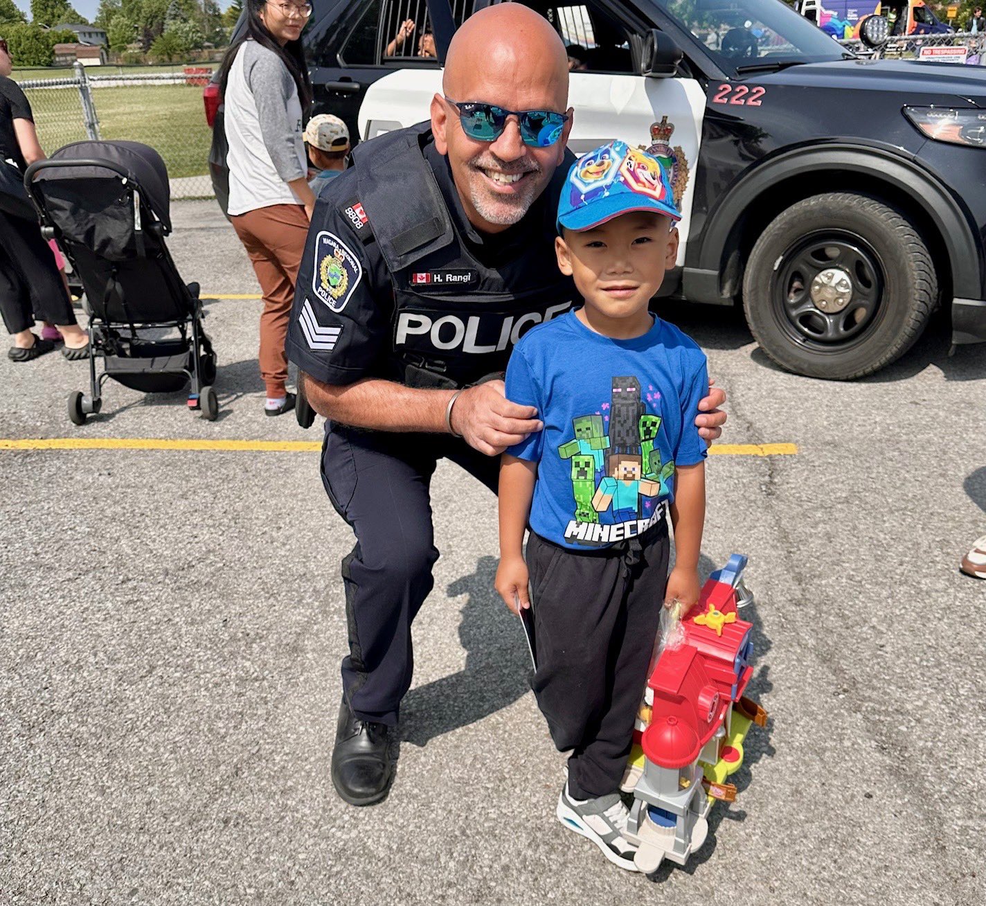 Officer with a young boy holding a toy