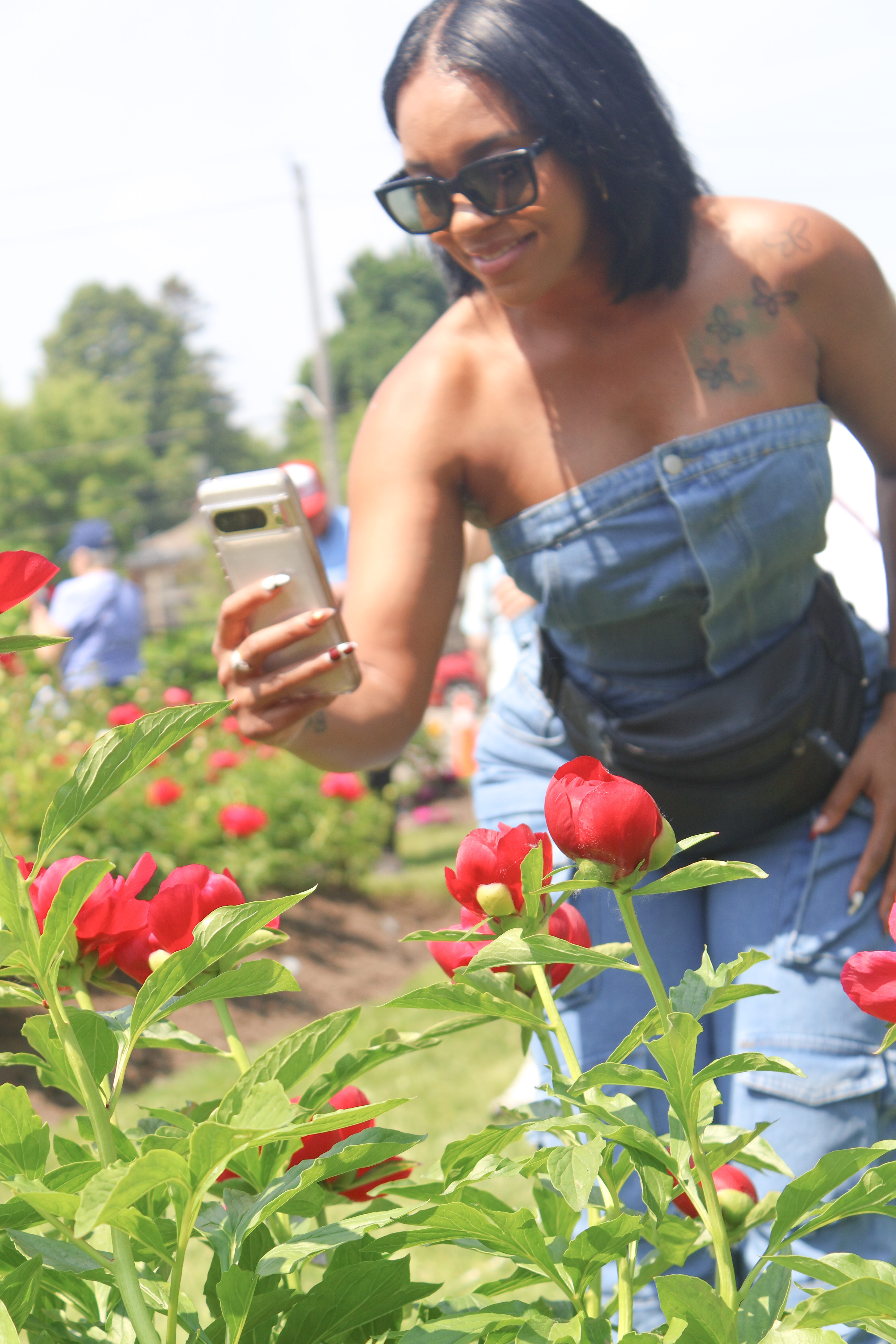 woman in peony garden taking photo