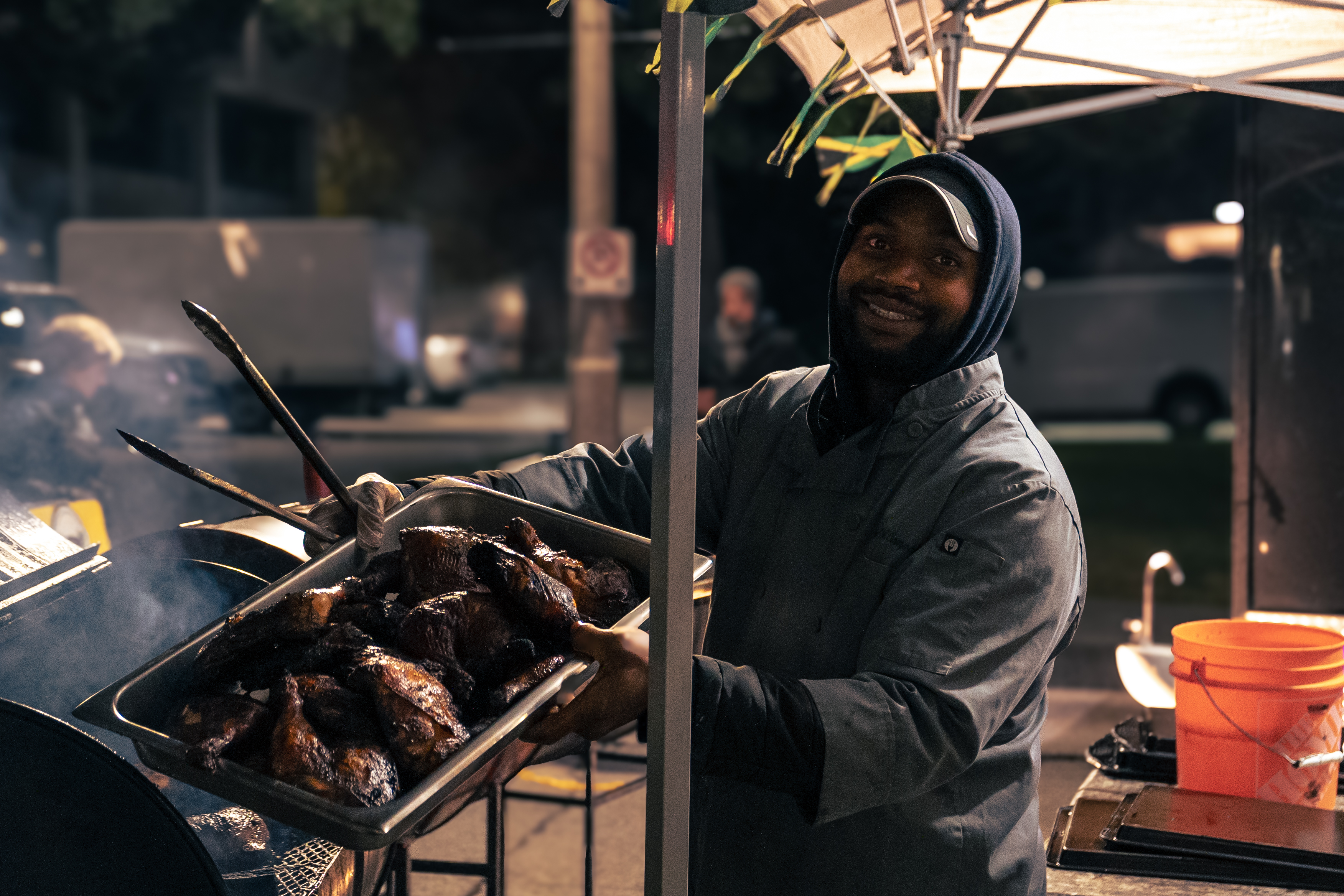 chef holding tray of chicken outside at market