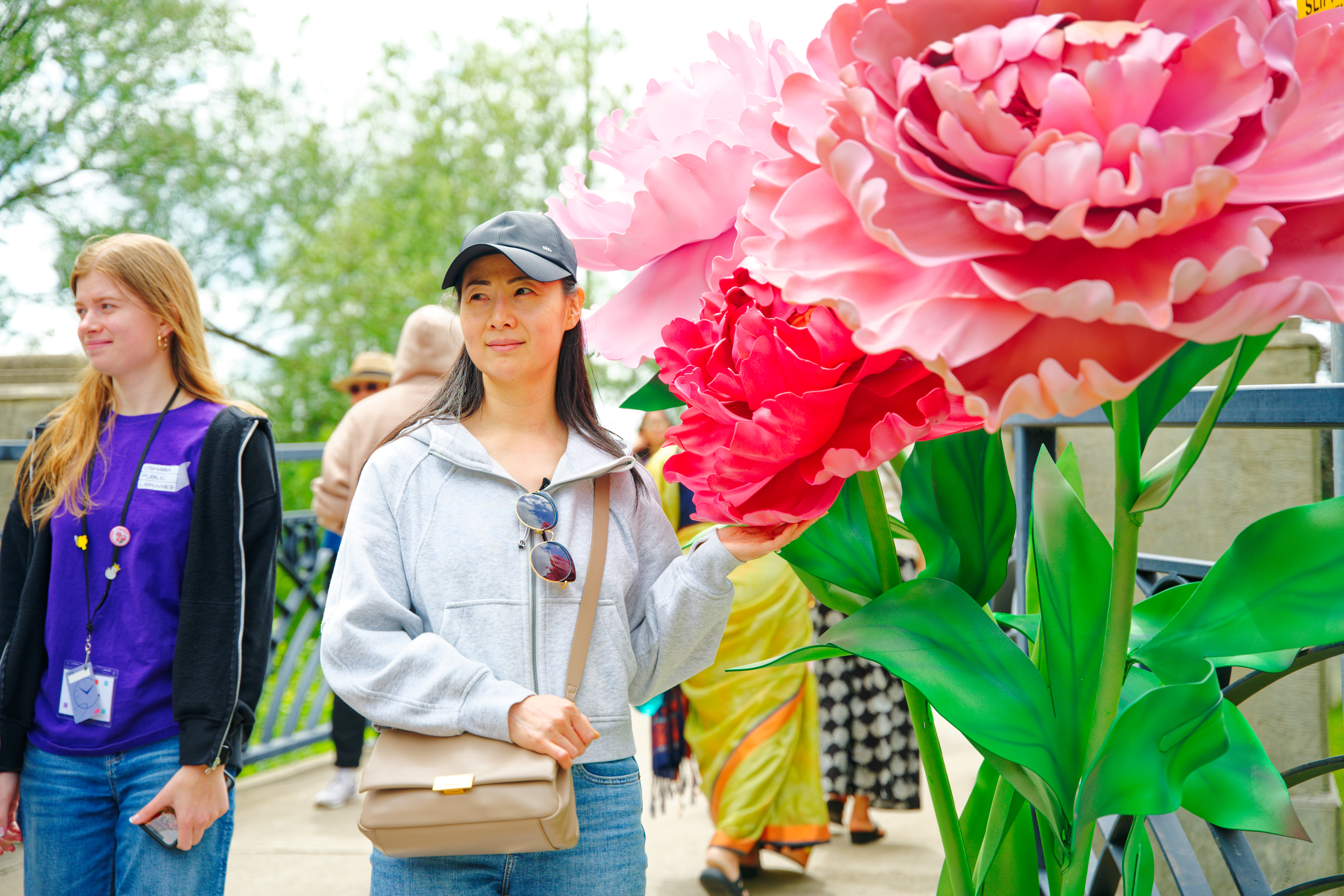 woman standing by large flower decor
