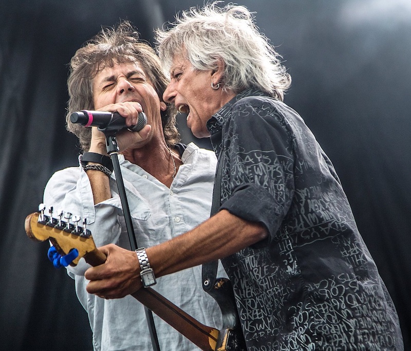 band vocalist and guitar player singing into microphone
