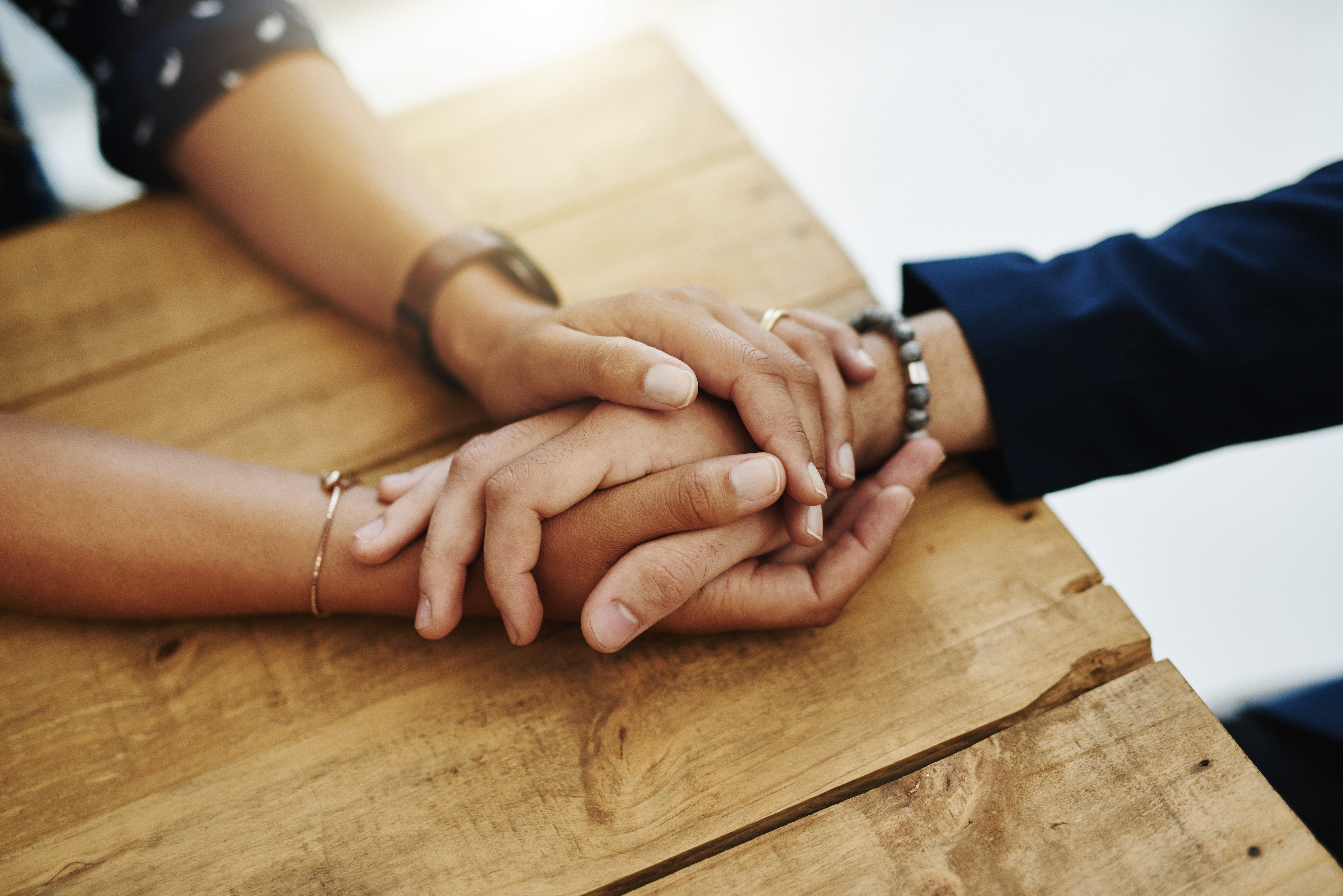 People holding hands on a table