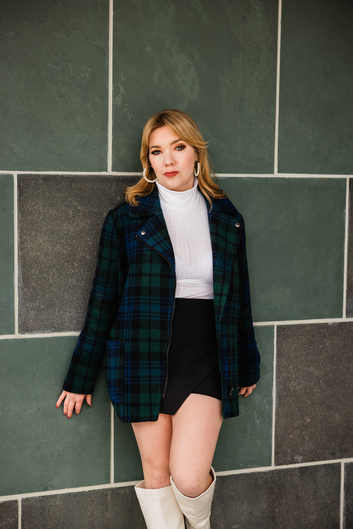 female standing in front of green wall