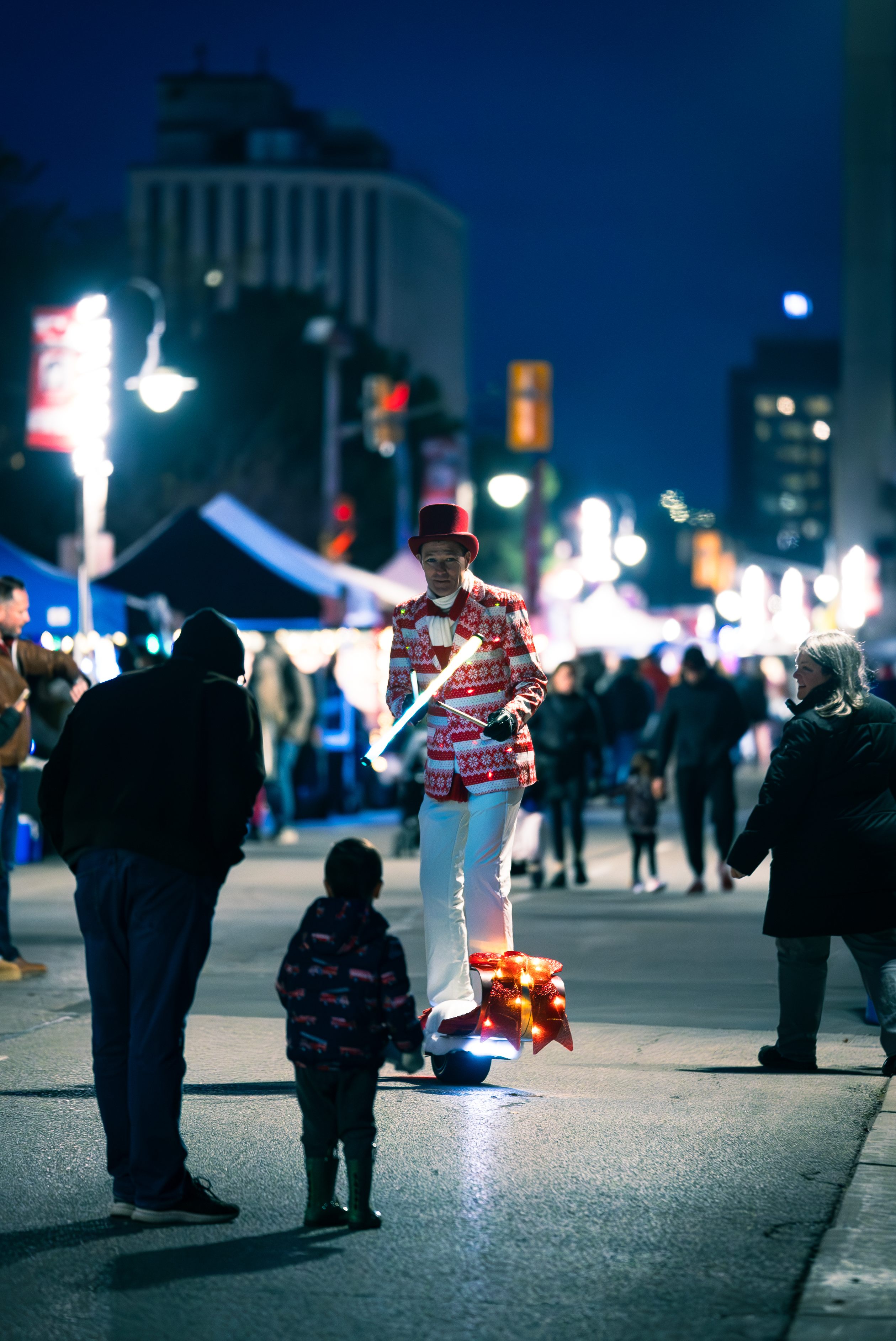 juggler riding a scooter through vendor market