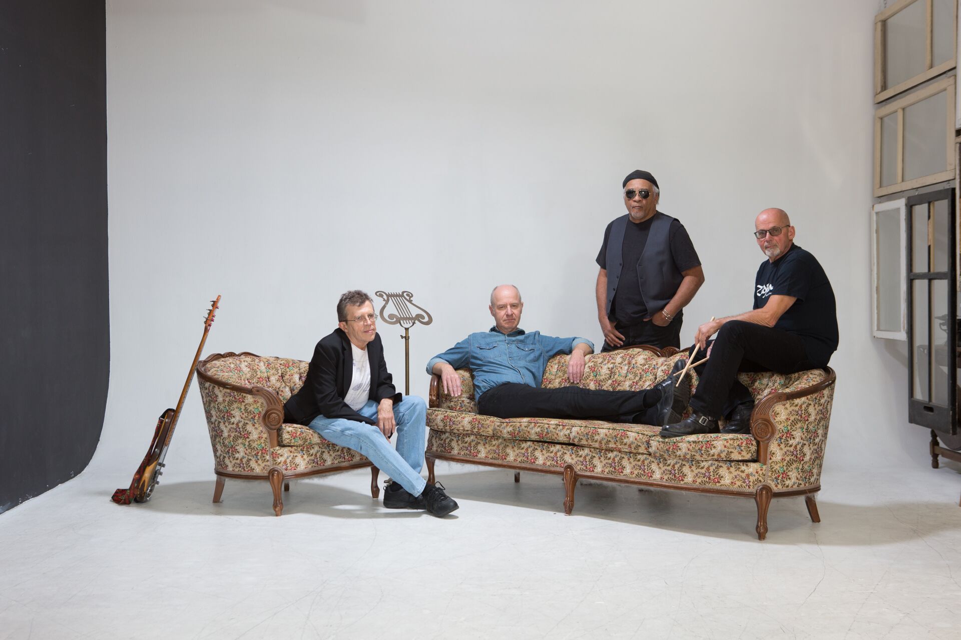four bandmates posing for a photo on a couch