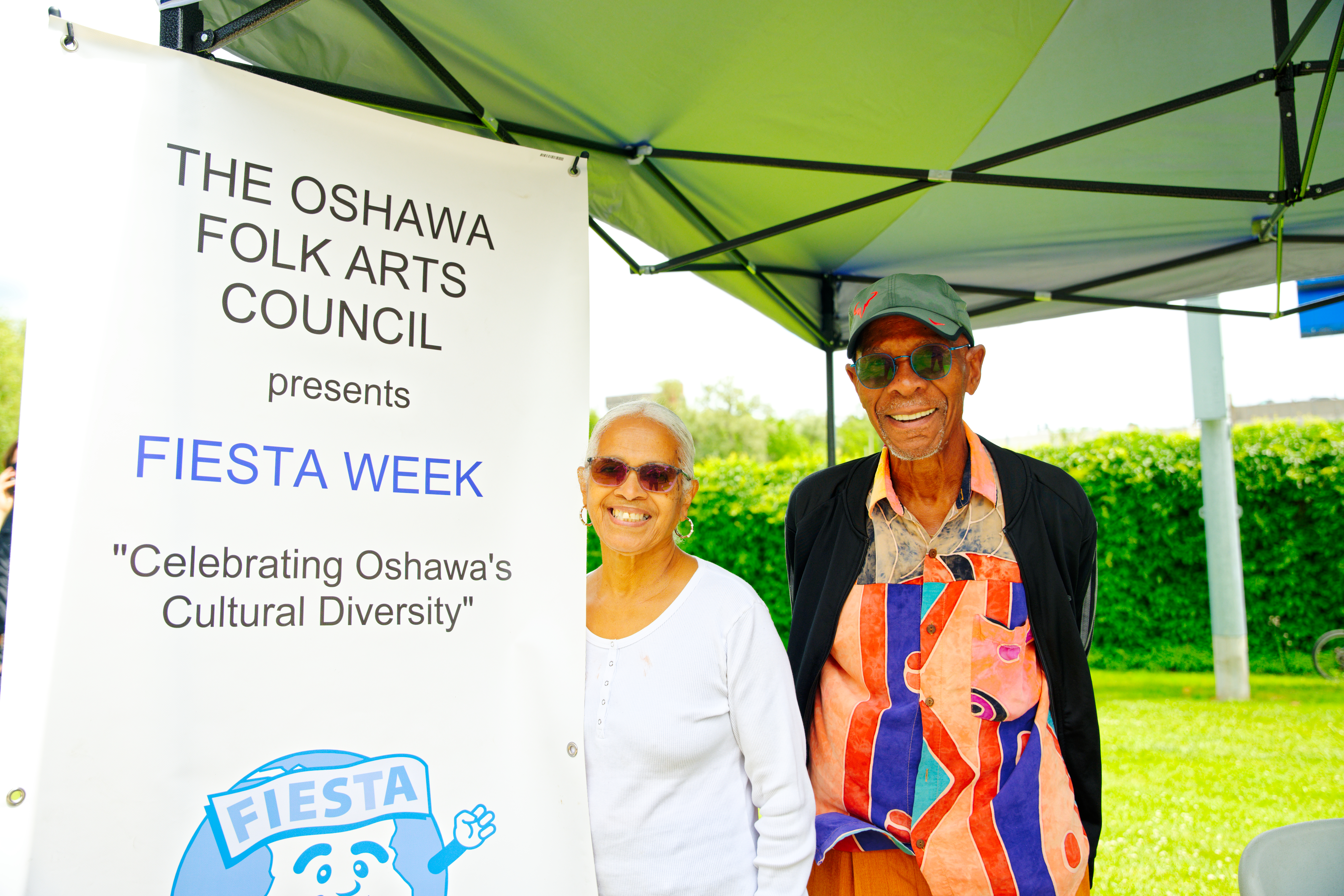 man and woman standing beside Oshawa Folk Art Council sign