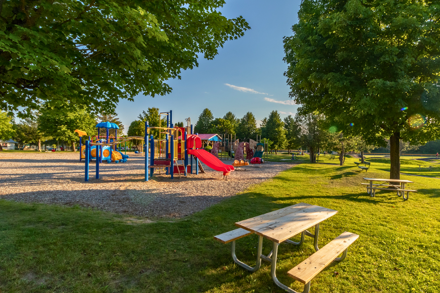 Park with playground surrounded by picnic tables