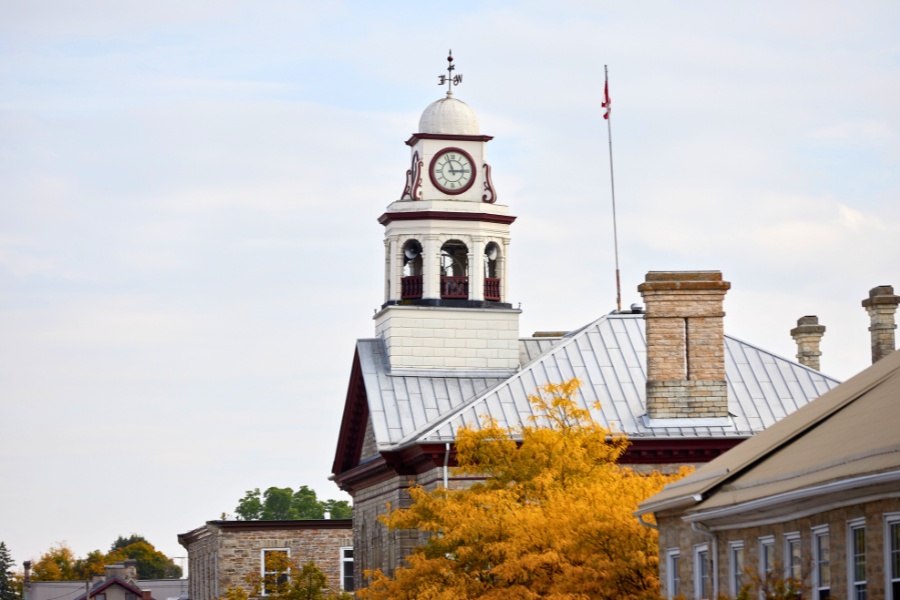 Side view of the clocktower on Perth Town Hall with a tree with yellow leaves in the foreground