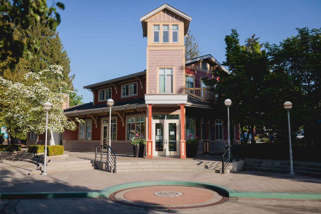 building in the centre with trees to the sides, and sidewalk in front