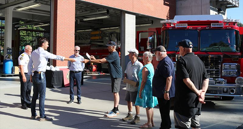 Port Moody Mayor Rob Vagramov and Seton Valley Volunteer Firefighters Society Director Ross Downey exchange papers to finalize Port Moody Fire Rescue’s donation of a retired 1995 Spartan fire engine. The engine is not pictured as it is currently being repaired.