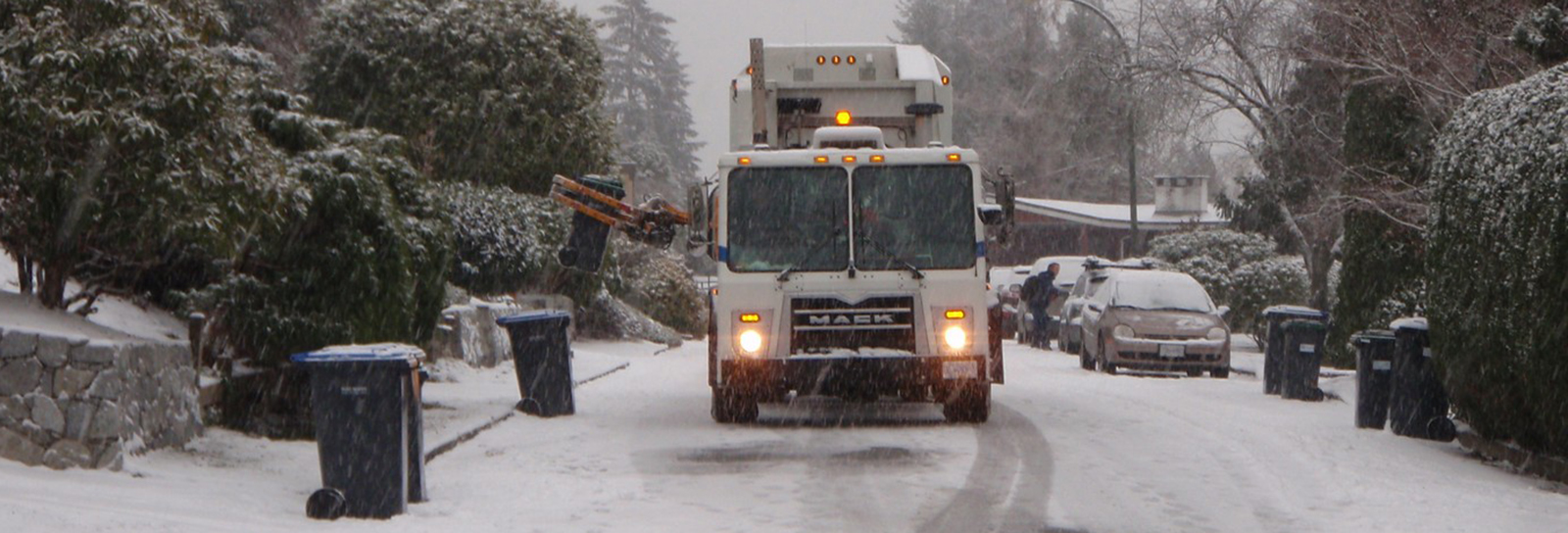 Waste collection truck driving in the snow