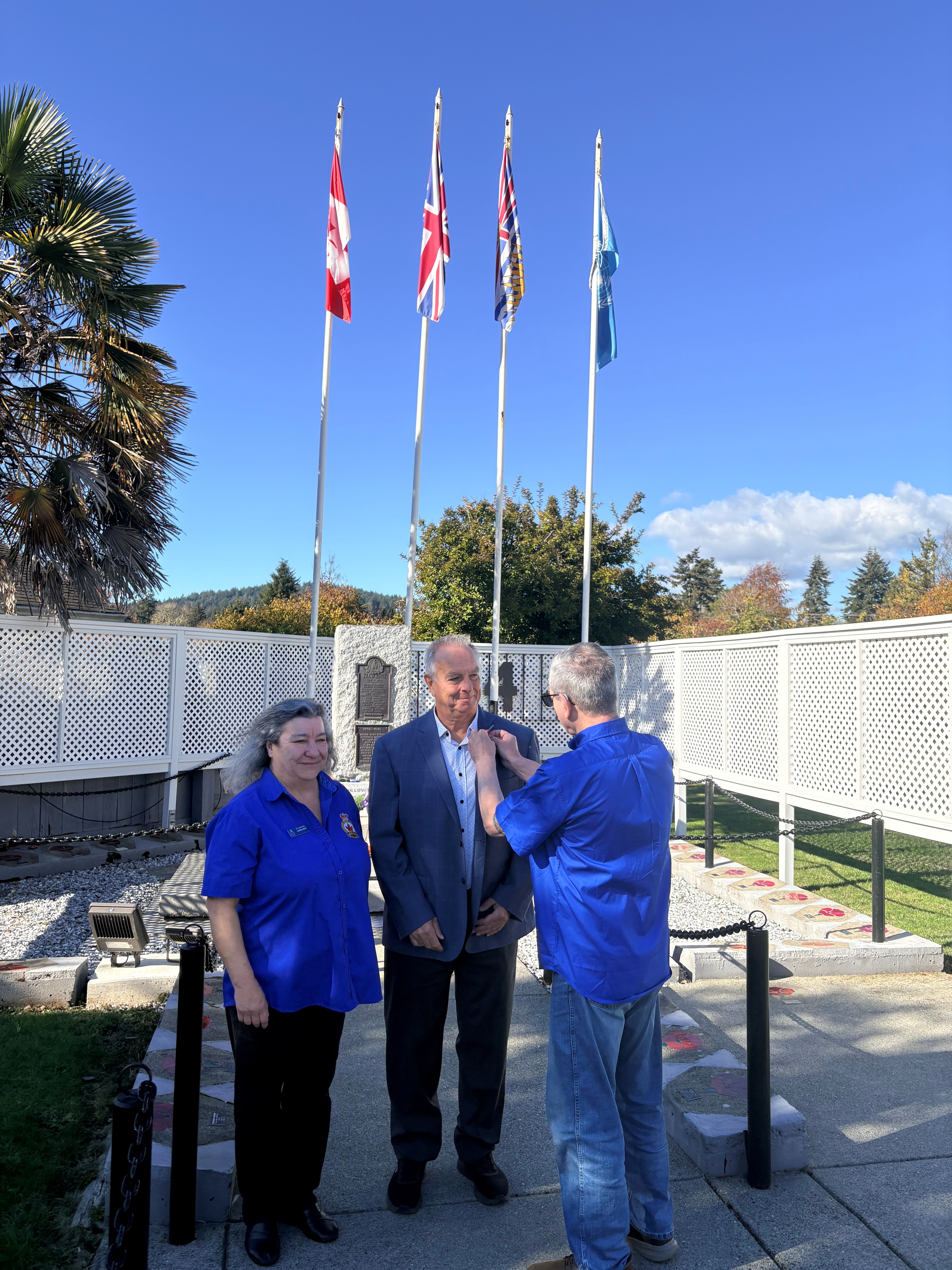 Royal Canadian Legion Branch 54 Vice-President Jim Tellenbach pins the first poppy on Mayor-elect Kevin Pearson’s jacket as Poppy Chair Laurie Hicks looks on at the Sooke Legion Cenotaph.