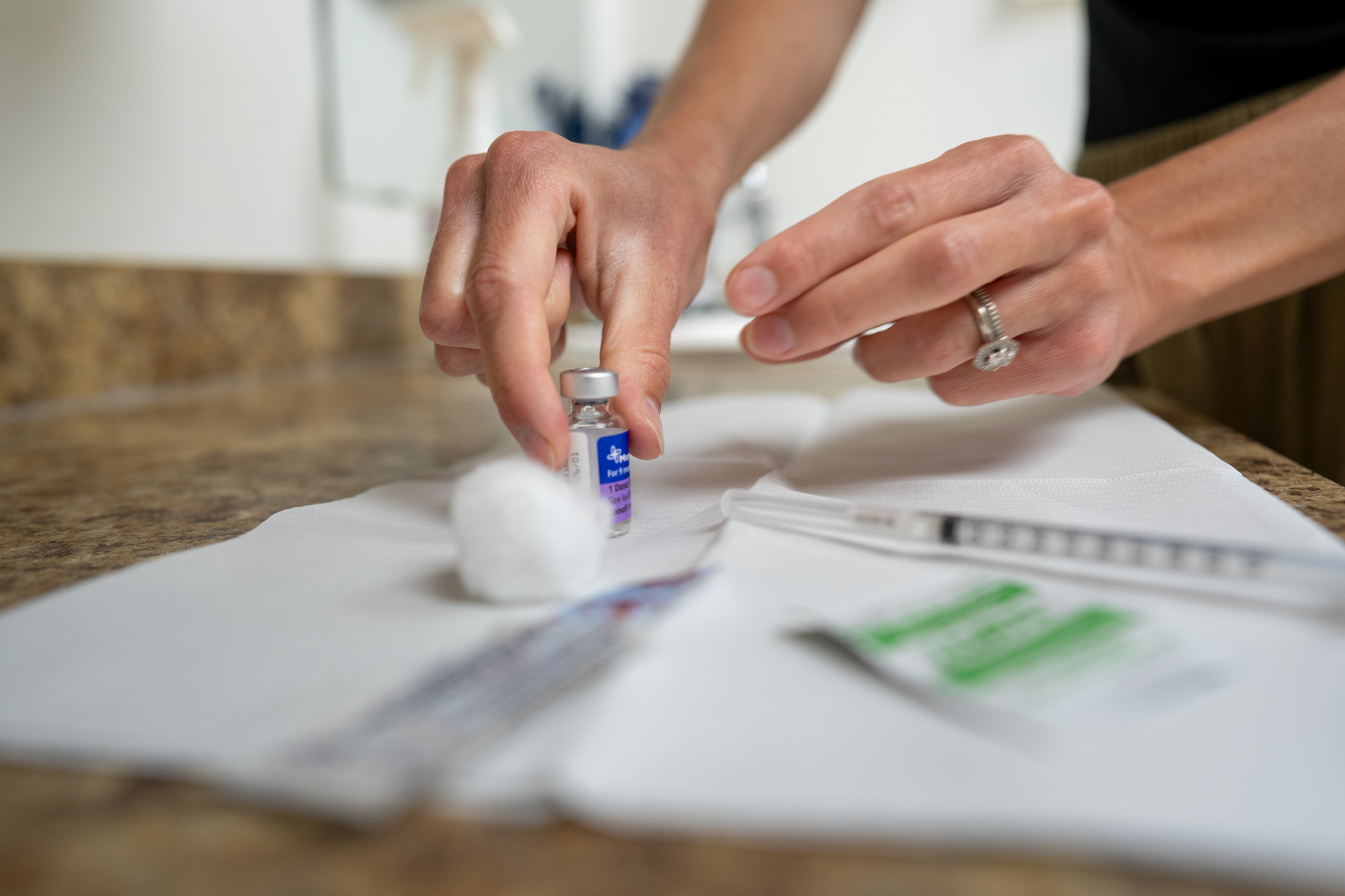 A nurse prepares a vaccine in a clinic setting