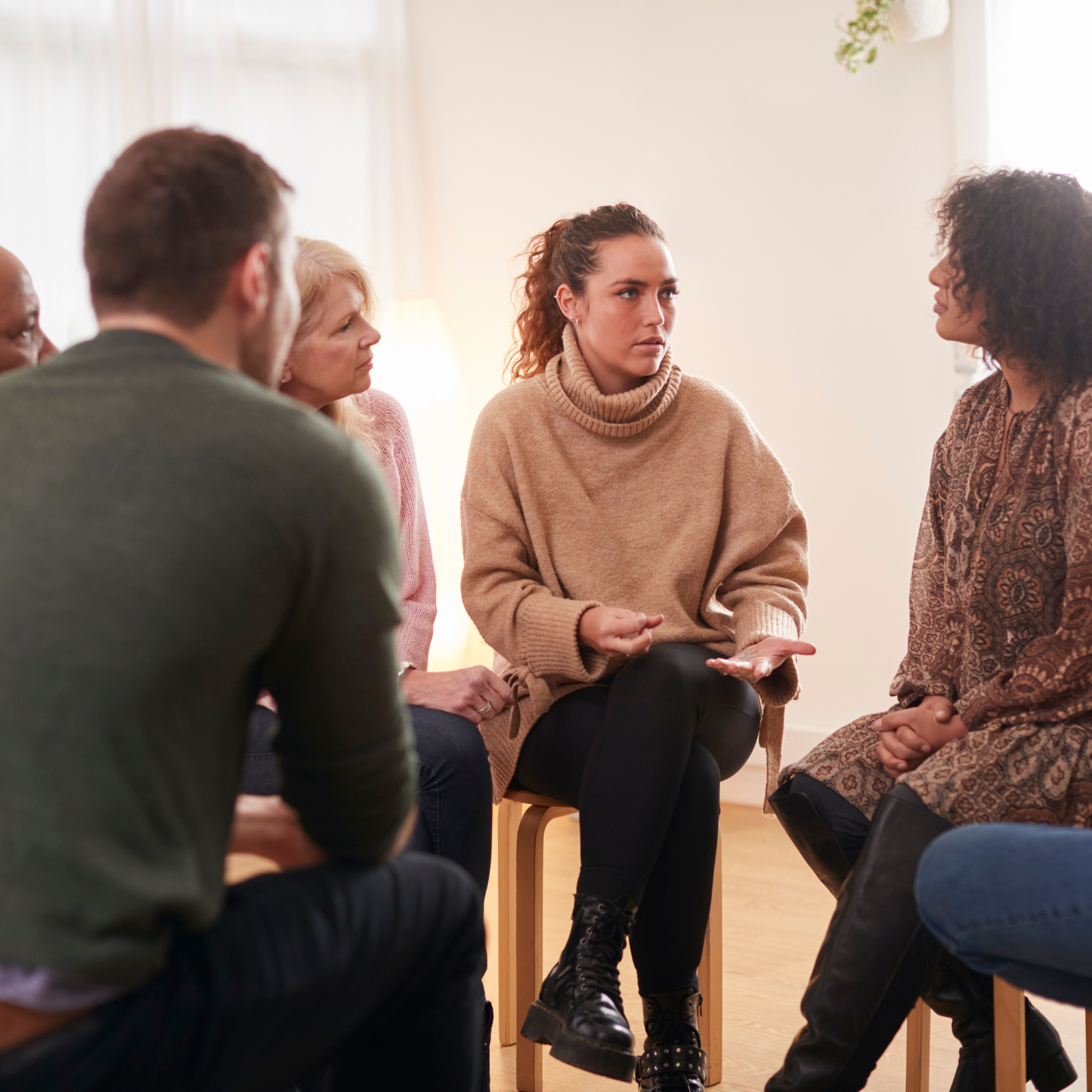 Group of adults sitting in a circle having a discussion 