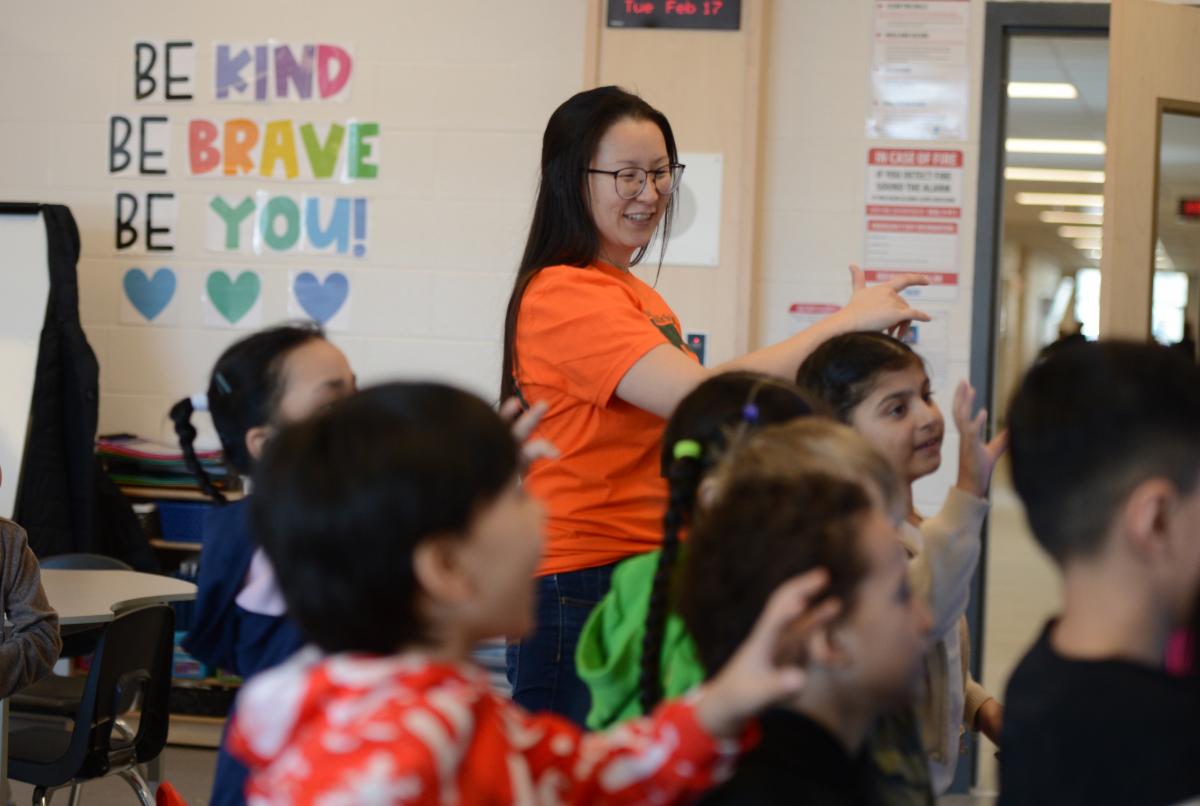 A teacher guides students on the first day of school at the new Turtle Island PS.